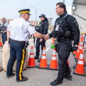 Deux policiers en uniforme opérationnel se serrent la main.