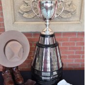 Un trophée est posé sur une table basse, avec à son pied une petite couverture blanche et, à côté, un Stetson de la GRC coiffant une paire de bottes de la GRC.
