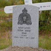 Un monument gris où figure l’emblème de la GRC et le nom du gendarme spécial Peter Esau, son matricule, sa date de naissance et la date de son décès surmontant une tombe au milieu d’un champ de croix 