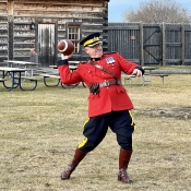 Un officier en tunique rouge lance un ballon de football