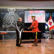 le keptin (capitaine) Donald Julien serre la main du commissaire adjoint Brian Brennan