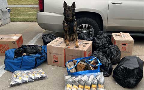 Un chien policier est entouré d'objets collectés pour les personnes dans le besoin.