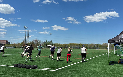 Plusieurs personnes s’éloignent en courant le long d’un terrain de football.