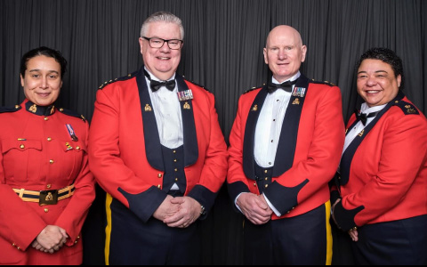 Quatre agents posent pour une photo en tunique rouge.