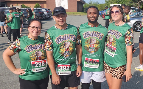 Quatre coureurs en tenue de course posent pour une photo.