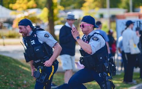 Deux gendarme de la GRC sont photographiés en train de courir en uniforme.