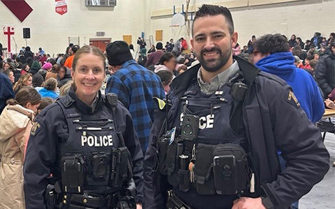 Deux agents de la GRC posent pour une photo avec une foule en arrière-plan.