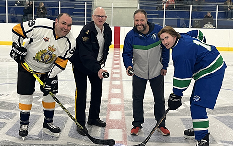 Les joueurs de hockey des deux équipes sourient à la caméra avant la mise au jeu.