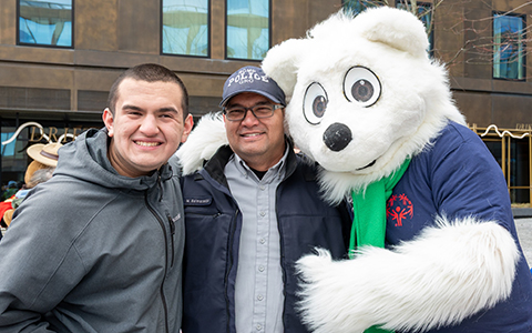 Un agent de la GRC est accompagné de son fils et d’une mascotte.
