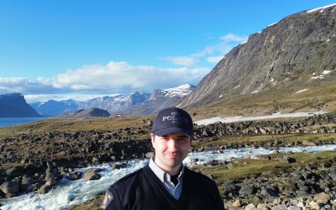 Prise de vue aérienne d'un terrain rocailleux près d'un lac glaciaire encadré de montagnes enneigées. 