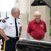 Un officier de la GRC en uniforme et un homme âgé vêtu d’un chandail rouge