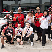 Deux policiers de la GRC en tunique rouge avec huit membres de l'équipe de cheerleading du ROUGE et NOIR d'Ottawa.