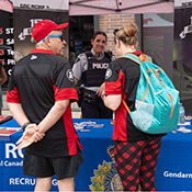 Deux membres de la GRC parlent avec deux personnes portant des vêtements du ROUGE et NOIR d'Ottawa.
