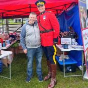 Le directeur exécutif de la Fondation de la GRC pose avec l’officier responsable du Carrousel, habillé en tunique rouge.