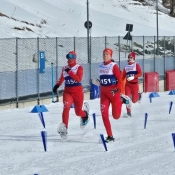 Trois athlètes de l'équipe canadienne de raquetteurs courent vers la ligne d'arrivée.