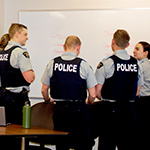 Un groupe de cadets écrivent leurs idées sur un tableau blanc