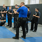 Deux instructeurs montrent aux cadets comment utiliser l'arme à impulsions de façon sécuritaire.