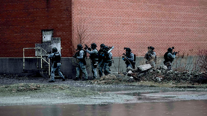 Des membres de l’Unité interarmées d’intervention du Canada (UIIC) et du Service de police de Toronto entourent un immeuble lors de l’exercice Vital Archer 2026. 