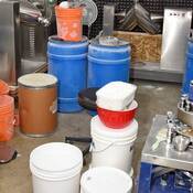 Photo d’un laboratoire de presses à comprimés contenant des machines à mélanger, des produits chimiques précurseurs de drogue en poudre, des presses à comprimés et des comprimés contrefaits finis.