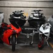 Une camionnette haut de gamme stationnée à côté de deux motocyclettes Ducati, de deux motomarines et d’une berline haut de gamme dans un garage souterrain.