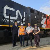 Des délégués de la GRC de l'Alberta et de la police du CN se tiennent devant un wagon pour marquer le début de la Semaine de la sécurité ferroviaire de l'Opération Gareautrain.