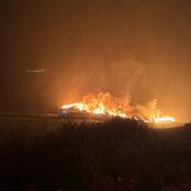 L’usine de traitement du poisson St. Mary’s Bay Fisheries Inc., vue de nuit, avec des flammes et des nuages de fumée qui s’échappent du bâtiment.