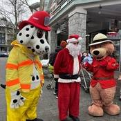 Photo prise lors de la collecte de denrées et de jouets de 2024 des services d’urgence de Whistler : l’agent de lutte contre les incendies Sparky, le père Noël et l’agent Ours prudent se tiennent debout côte à côte.