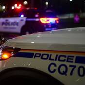 Voiture de police du Détachement de la GRC de Coquitlam et, en arrière-plan, policier du Service de police de Port Moody