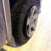 Gros plan d’un pneu de véhicule partiellement détaché de sa jante, illustrant les dangers d’une pression insuffisante par temps très froid.