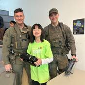 Membres de l'équipe du Groupe tactique d’intervention posent avec une enfant