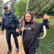 Une élève montre fièrement le poisson qu’elle a attrapé.