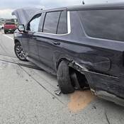 Les gyrophares du VUS de police noir endommagé de marque Chevrolet étaient allumés sur le bord de la route lorsqu’il a été heurté par un conducteur qui n’a pas ralenti ni changé de voie