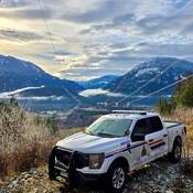 Camion de police surplombant le Village of Pemberton, et montagnes en arrière plan.
