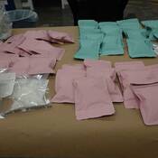 Paquets de méthamphétamine découverts dans la valise et exposés sur un bureau.