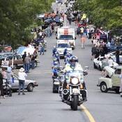 Photo des cyclistes du Tour de Rock sous escorte policière, dans une rue bondée