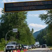 Un policier s’adresse à un conducteur dans la circulation à un point de contrôle près du festival de musique Shambhala