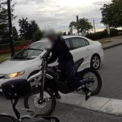 Un conducteur au volant d’une moto électrique non assurée qui fuit la police. Le motocycliste est un jeune homme mince à la peau brune et au menton fuyant. Il portait des vêtements noirs et un casque de vélo blanc