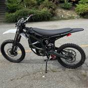 Une moto tout-terrain électrique garée dans un stationnement.