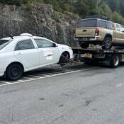 Un taxi Toyota Corolla blanc est remorqué loin de la route Sea to Sky pour excès de vitesse