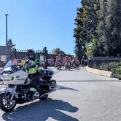 Photo d’un agent des Services de la circulation du Détachement de la GRC de Mission sur une moto de police escortant les cyclistes de Policiers contre le cancer hors du détachement.