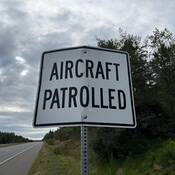 Panneau routier disant « Aircraft patrolled » (surveillance aérienne)