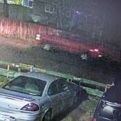 Photo provenant d’une caméra de vidéosurveillance et montrant la camionnette suspecte rouge. La photo est très floue.