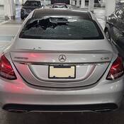 Un véhicule Mercedes argenté dont la lunette arrière est fracassée.