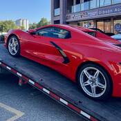 Une Corvette rouge en train d’être chargée sur une dépanneuse à Coldstream, en Colombie-Britannique