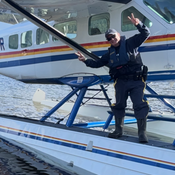 Le gendarme Darren Maizis debout sur l’hydravion de la GRC sur la rive d’un lac éloigné dans la région de Skeena.