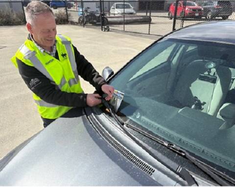 Eng: Thumbnail: Photo of Sandro Piroddi Kamloops RCMP Detachment Crime Prevention Coordinator placing tip card on vehicle windshield