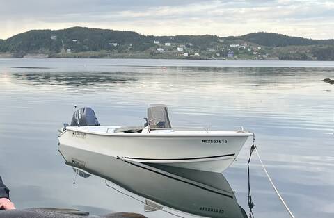 A white vessel, with a Yamaha outboard motor is moored in the water. The HIN on the front of the boat reads “NL2597915” and the “Ocean Fisher” is written on the stern.