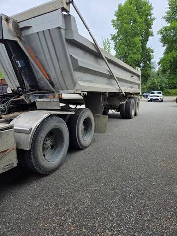 Dump truck parked with a white unmarked police vehicle parked behind it.