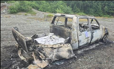 Photo of a burned pickup truck near a Forest Service Road