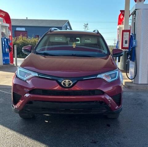 A red Toyota SUV, seen from the front, parked next to gas pumps.